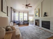 Bright living room features fireplace, ceiling fan, and windows letting in natural light at 740 Deer Clover Cir, Castle Pines, CO 80108