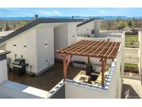 Relaxing rooftop deck featuring stylish pergola, seating area, and a grill setup at 1336 Sheridan Blvd # 108, Denver, CO 80214