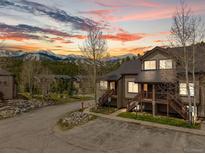 Inviting mountain condo with wood siding, private balconies, and stunning views of snowy peaks at sunset at 10 River Park Dr # A, Breckenridge, CO 80424