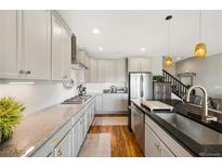 Modern kitchen boasts granite countertops, stainless steel appliances, and ample cabinet space at 8872 E 47Th Ave, Denver, CO 80238