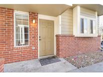 Inviting front entrance with brick accents, a light, and a beige-painted front door at 9032 Gale Blvd # 1, Thornton, CO 80260