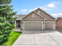 Charming home with a three-car garage, well-maintained lawn, and mature trees at 15635 Dawson Creek Dr, Monument, CO 80132