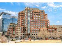 Striking condo building with brick facade, clock tower and many windows, located near a park area at 1590 Little Raven St # 702, Denver, CO 80202
