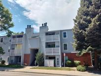 Exterior view of condo building with balconies, red brick and gray siding at 7665 E Eastman Ave # 104A, Denver, CO 80231