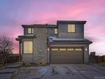 Two-story home with stone accents, solar panels, an attached two car garage, and well-maintained landscaping at 17265 E 110Th Ct, Commerce City, CO 80022