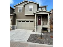 Two-story home featuring a two-car garage, a charming front porch, and low-maintenance landscaping at 9041 Redfield Ln, Parker, CO 80134