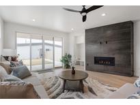 Bright living room with a sleek fireplace, sliding glass doors, and modern ceiling fan at 1953 W 47Th Ave, Denver, CO 80211