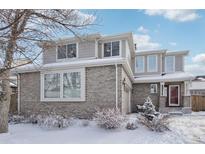 Two-story house with brick facade, snow-covered landscaping, and red front door at 20242 E Lasalle Pl, Aurora, CO 80013