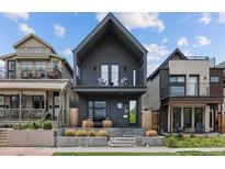 Modern two-story home with a striking dark exterior, balcony, and manicured front yard at 3409 Navajo St, Denver, CO 80211