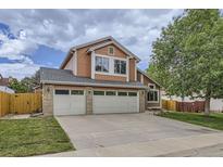 Inviting two-story home featuring a three-car garage and manicured front lawn at 4205 E 106Th Pl, Thornton, CO 80233