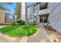 Inviting exterior with lush lawn and a walkway leading to the home's entrance and second story at 6410 S Dayton St # I05, Englewood, CO 80111