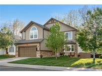 Charming two-story home with a well-manicured lawn, mature tree, and an attached two-car garage at 5997 S Yakima St, Aurora, CO 80015