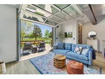 Bright living room with a glass garage door opening to a patio and an outdoor view, featuring stylish furnishings at 4021 S Teller St, Lakewood, CO 80235