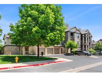 Well-maintained condo community with mature tree, garages, sidewalks, and visible fire hydrant at 7422 S Quail Cir # 1624, Littleton, CO 80127