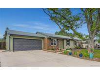 Charming single-story home with a well-manicured lawn, mature tree, and two car garage on a sunny day at 5925 W 86Th Ave, Arvada, CO 80003