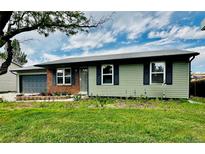Charming single story home with a green exterior, blue shutters and brick accents at 5925 W 86Th Ave, Arvada, CO 80003