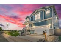 Charming two-story home with blue siding, white trim, a front porch, and a two-car garage at 900 Eldorado Ln, Louisville, CO 80027