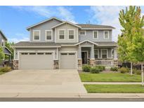 Beautiful two-story home featuring an attached three-car garage and inviting front porch at 23895 E Rocky Top Pl, Aurora, CO 80016