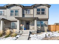 Charming two-story home with a covered porch, gray exterior, and a well-maintained front yard at 28314 E 6Th Pl, Watkins, CO 80137