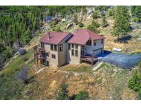 Stunning mountain home featuring a large driveway, tiered balconies, and incredible views at 1295 Hy Vu Dr, Evergreen, CO 80439