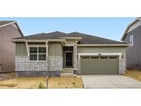 Charming home featuring stone accents, a well-manicured lawn and a two-car garage at 15274 Milwaukee St, Thornton, CO 80602
