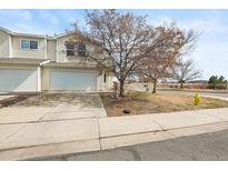 Charming townhouse featuring an attached garage, well-maintained lawn, and inviting curb appeal at 892 Macaw St, Brighton, CO 80601