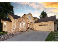 Charming home featuring a stone facade, two-car garage, and manicured landscaping at 6524 Surry Pl, Parker, CO 80134