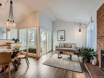 Bright living room features wood floors, fireplace and access to balcony at 3351 S Monaco Pkwy # F, Denver, CO 80222