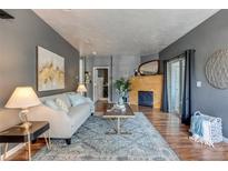 Bright living room features hardwood floors, fireplace, and comfortable seating at 8055 W Eastman Pl # 104, Lakewood, CO 80227