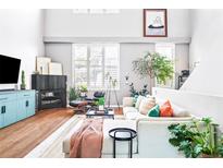 Comfortable living room with a modern fireplace, cozy seating, and large windows with bright light at 7525 E 1St Pl # 1010, Denver, CO 80230