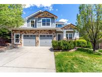 Charming two-story home with stone accents, a two-car garage, and a well-manicured lawn at 7234 S Kellerman Way, Aurora, CO 80016