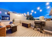 Inviting rooftop deck with string lights, a cozy seating area, fire pit, and grill perfect for outdoor relaxation at 2922 W 26Th Ave # 4, Denver, CO 80211