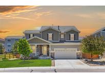 Beautiful two-story home featuring a manicured lawn, stone accents, and a spacious two car garage at 3554 E 143Rd Pl, Thornton, CO 80602