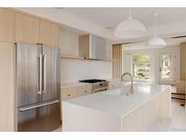 Bright, modern kitchen featuring stainless steel appliances, island sink, and light wood cabinets at 4322 Quivas St, Denver, CO 80211