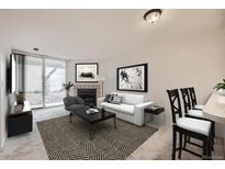 Inviting living room featuring a cozy fireplace, neutral tones, and sliding door access to the outside at 11103 E Alameda Ave # 102, Aurora, CO 80012