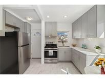Bright kitchen with stainless steel appliances, light gray cabinets and white backsplash tiles at 2570 Jay St, Edgewater, CO 80214