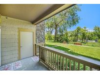 View from the patio of the yard with two benches and a large tree on a sunny day at 8039 Lee Dr # 2, Arvada, CO 80005