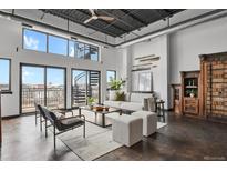 Bright living room featuring an open floor plan, spiral staircase, and city views at 2715 Blake St # 304, Denver, CO 80205