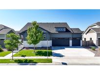 Charming two-story home with a well-manicured lawn, three-car garage and beautiful landscaping at 15920 Buffalo Run Dr, Commerce City, CO 80022
