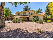 Charming home featuring unique architectural design, and mature landscaping, all under a clear blue sky at 305 Titan St, Aurora, CO 80011