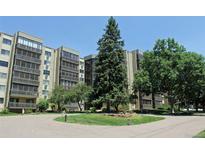 Multi-story condo building showcasing a landscaped front area, mature trees, and well-maintained facade at 14390 E Marina Dr # 104, Aurora, CO 80014
