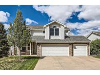 Charming two-story home with a well-manicured lawn, stone accents, and a spacious three-car garage at 2369 Bayberry Ln, Castle Rock, CO 80104