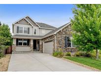 Beautiful two-story home with stone accents, manicured lawn, and a welcoming front porch at 8071 Tabor St, Arvada, CO 80005