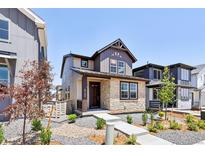Charming two-story home featuring stone accents, landscaped front yard, and welcoming entrance at 8787 Whiteclover St, Littleton, CO 80125