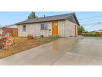 Newly renovated single Gathering home with white brick and a new, inviting orange front door at 272 Balsam Ave, Brighton, CO 80601