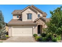 Charming two-story home with a stone facade, attached two-car garage, and well-maintained landscaping at 2276 S Norse St, Lakewood, CO 80228