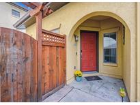 Inviting front entrance with a charming wooden gate and a vibrant red door under a sheltered archway at 9654 Martin Luther King Jr Blvd, Denver, CO 80238