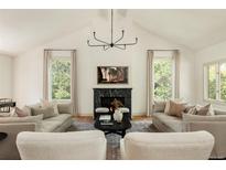 Bright living room boasts vaulted ceilings, cozy seating around a fireplace, and natural light at 24 Spyglass Dr, Littleton, CO 80123