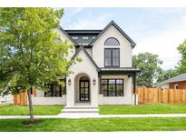 Charming, modern two-story home with black trim, white brick, an arched front door, and a beautiful landscaped yard at 4452 Xavier St, Denver, CO 80212