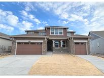 Beautiful two-story home with brown siding, stone accents, and a three-car garage at 3979 Descent St, Castle Rock, CO 80108